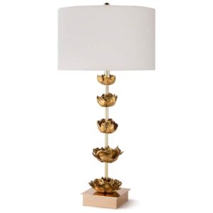 Gold leaf table lamp on a dining sideboard below a large metal relief wall sculpture