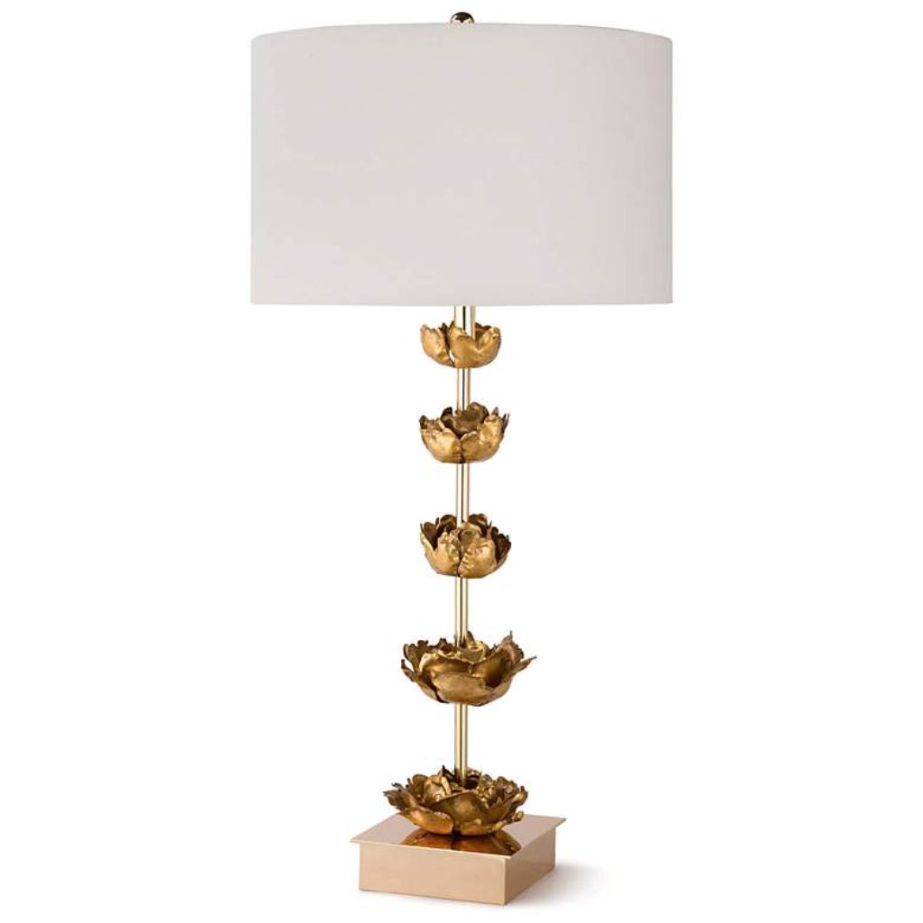 Bird sculpture — gold petal sculptural lamp beside an upright bronze bird sculpture on a living room console