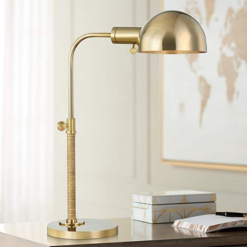 The thinker sculpture — adjustable brass desk lamp in a study with Rodin reference books and a bronze figurine