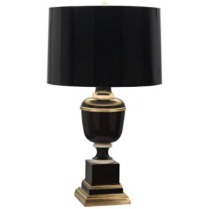 Aged brass ceramic table lamp on a styled bedroom nightstand with books and a small plant