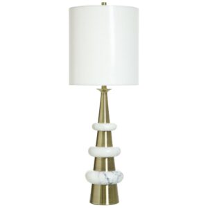 White ceramic lamp beside cream linen bedding and a small plant — organic modern bedroom styling
