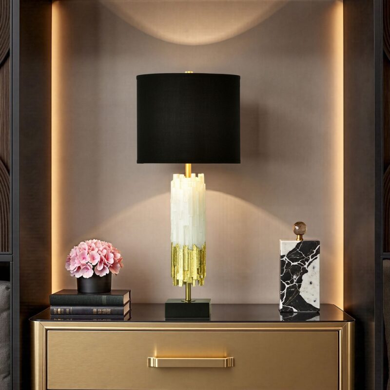 Minimalist bedroom table lamps — matte black ceramic column on a floating white nightstand with linen bedding