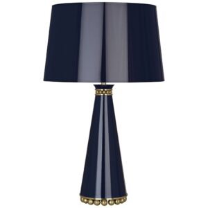 Traditional brass table lamp with white empire shade on a mahogany end table in a formal living room