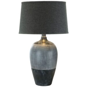 Aged brass table lamp with white empire shade on a warm walnut nightstand in a traditional master bedroom