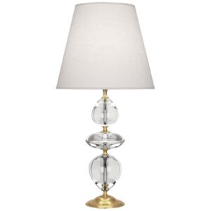Artisan crystal table lamp with brass base reflecting prismatic light in a luxury dining room