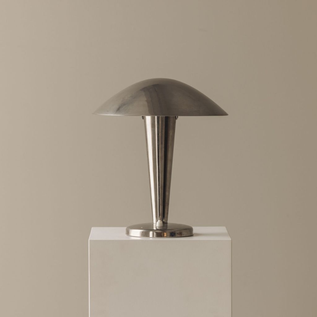 Collection of sconce lamp shades in different styles — empire, drum, bell, and half-shade — displayed on brass wall sconces