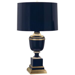 Light sculpture — cobalt glass table lamp on a console table with light emanating through the translucent glass body creating a jewel-toned glow