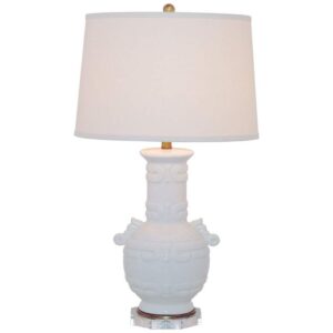 Green ceramic mid-century modern table lamp on a dark walnut nightstand in a contemporary bedroom