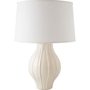 Pale blue glass table lamp with white drum shade in a coastal bedroom with natural linen and rattan