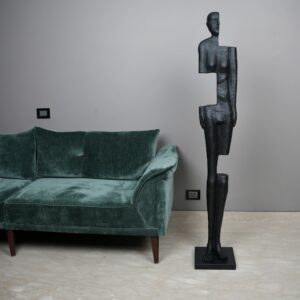 Sculpture materials for home decor — bronze accent lamp beside a cast bronze sculpture on a console, showing warm material temperature in a transitional living room