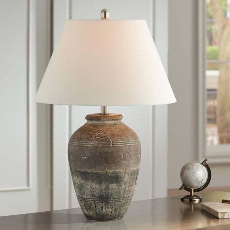 Light blue table lamp on a white linen nightstand in a serene coastal bedroom with natural cotton bedding