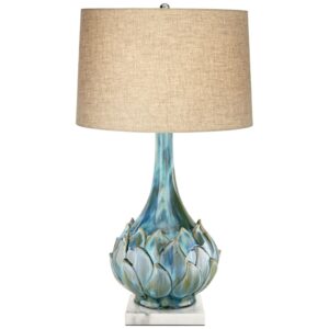 Pair of ceramic table lamps symmetrically styled on either side of a living room sofa