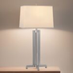 Luxury table lamps in a dark living room — crystal lamp and gold base lamp reflecting warm light across navy walls