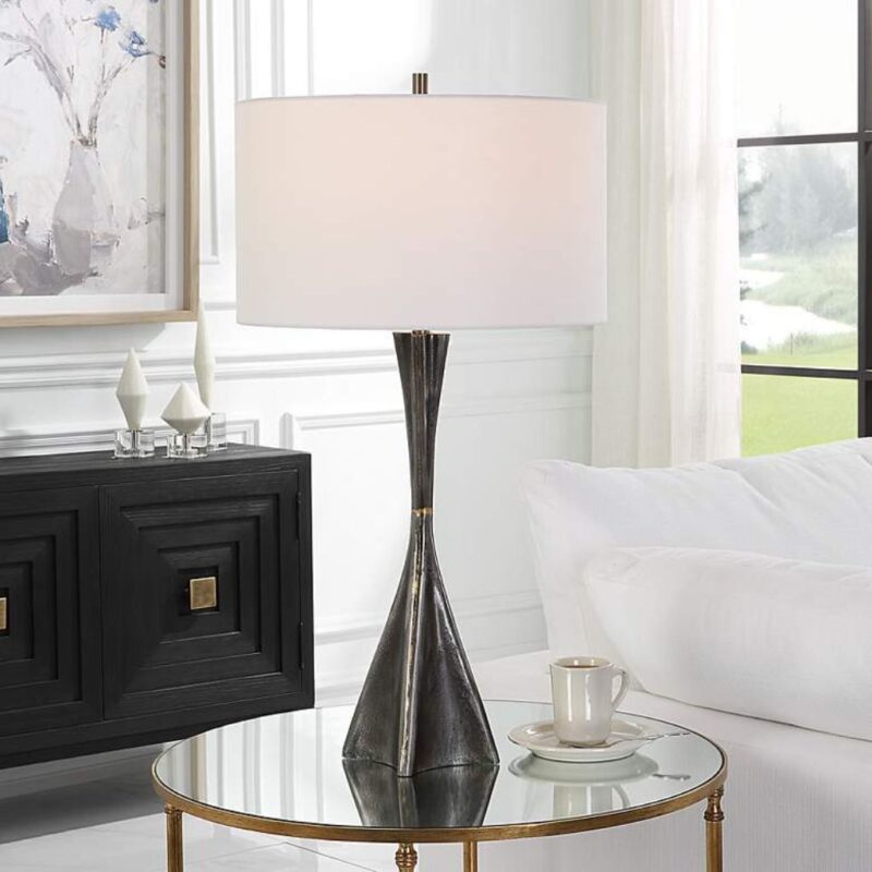 How to clean a table lamp — soft cloth wiping a ceramic table lamp base and dusting a fabric shade