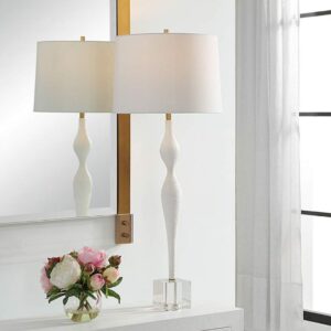 Handmade ceramic sculpture home decor — sage green ceramic lamp beside a studio ceramic sculpture on a natural wood shelf