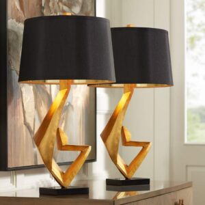 Wood wall sculptures — gold leaf sculptural lamp on a console table below a large carved wood wall panel