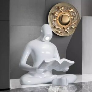 Colored glass sculpture modern interior — slim modern accent lamp providing warm neutral light beside a cobalt glass sculpture on a contemporary console
