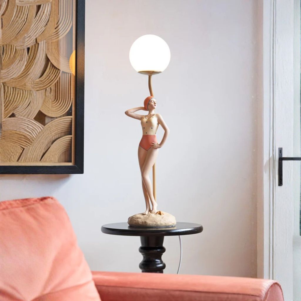 Interior designer how to style a table lamp on a console table with books, a vase, and a sculptural object