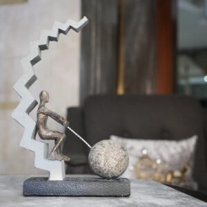 Bronze sculpture home decor — adjustable brass desk lamp beside a bronze figurine in a traditional home study