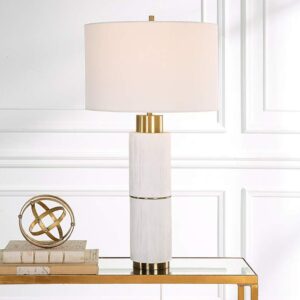 3D wall art sculptures — slim aged brass column lamp beside a dimensional metal wall panel in a contemporary living room