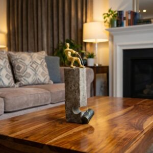 Cast iron sculpture home decor — aged black lamp beside a cast iron bird sculpture on a contemporary console against a light warm background