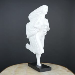 Rodin bronze reproduction at home — bronze accent lamp creating warm side light beside a Rodin-style bronze reproduction in a formally arranged study