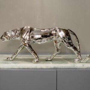Bronze sculpture patina application — adjustable brass desk lamp directing precise warm light across a bronze sculpture during patina evaluation in a home studio