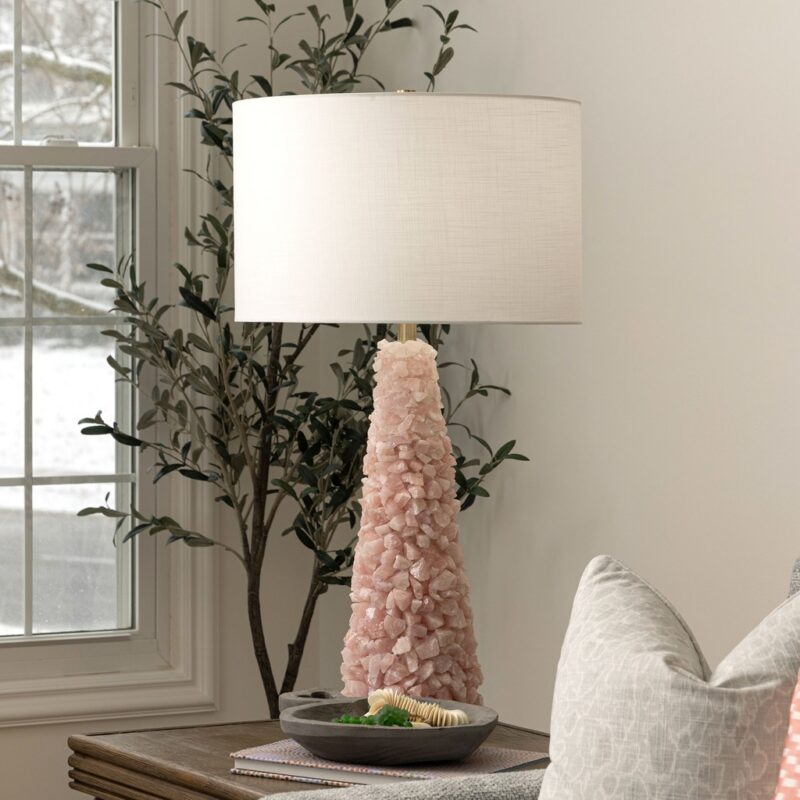 Table lamps for living room — gold leaf sculptural lamp creating warm ambient light at seated eye level beside a transitional sofa