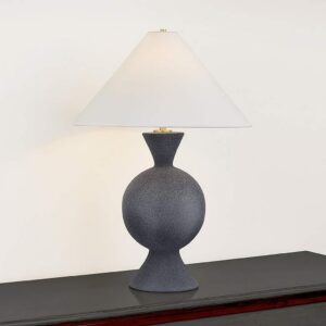 Coastal table lamps — pale blue ceramic lamp in a coastal bedroom with white bedding, natural wood surfaces, and sea-influenced textiles