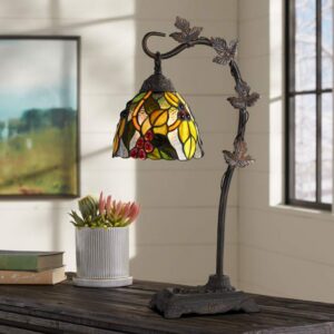 Styling table lamp console — adobe brown lamp as the primary vertical element in an asymmetrical console vignette with varied-height companion objects