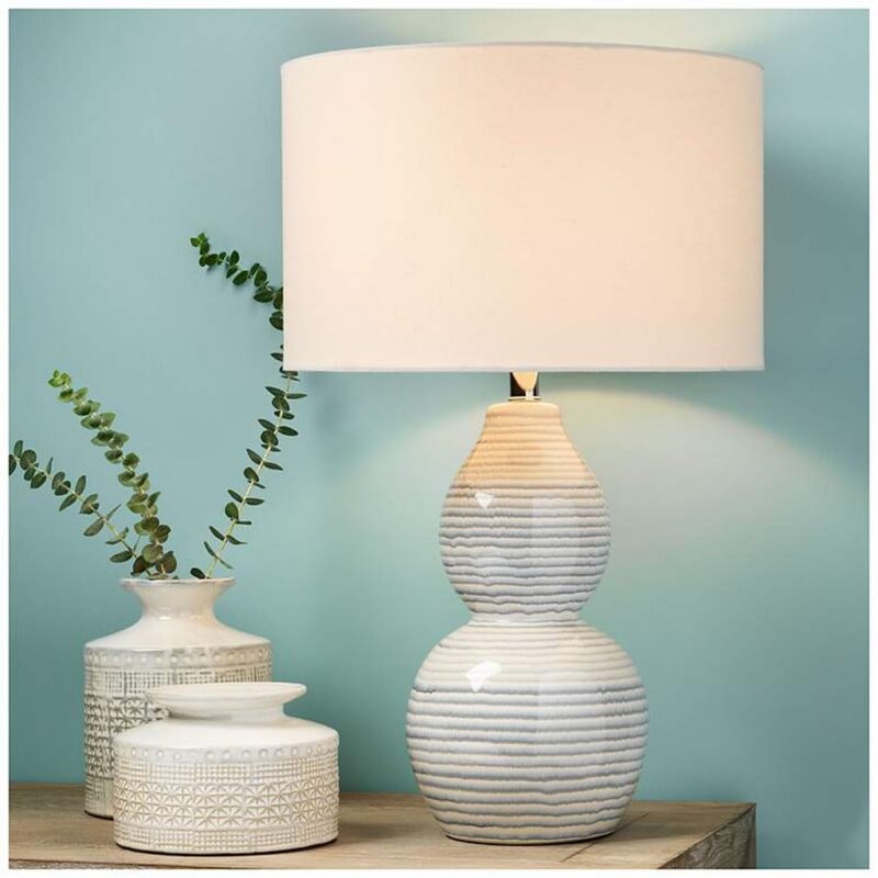 Table lamps for dining room — Zeus gold leaf lamp on a sideboard creating secondary warm ambient light beside a chandelier
