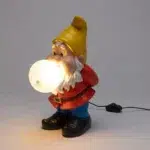 Back view of the gnome lamp showing hands clasped behind the red jacket