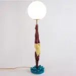 Retro table lamp — yellow diver plunging from white glass globe, teal splash base
