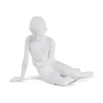 White boy-with-orb sculpture lamp glowing softly on a bedside table