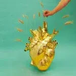 Oversized gold heart vase styled in an entryway