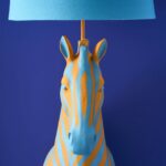 Floor Lamp Zebra Print Blue and Orange, shown illuminated in a living room setting
