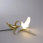 Table Lamp Banana Gold, shown on a sideboard