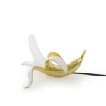 Table Lamp Banana Gold, shown on a sideboard