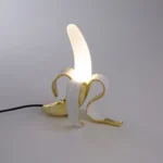 Table Lamp Banana White and Gold, shown on a sideboard