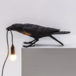 Wall Lamp Raven Black Playing Outdoor, shown mounted on a patio wall