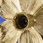 Wall Lamp Flower Gold, shown mounted in a bedroom setting