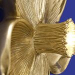 Wall Lamp Flower Gold, shown mounted in a bedroom setting