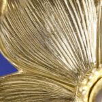 Wall Lamp Flower Gold, shown mounted in a bedroom setting