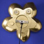 Wall Lamp Flower Gold, shown mounted in a bedroom setting