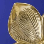Wall Lamp Flower Gold, shown mounted in a bedroom setting