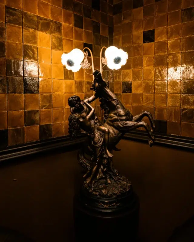 Decorative bronze floor lamp sculpture displayed in an elegant interior