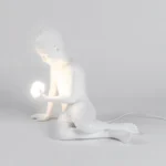 Table Lamp Innerglow Boy, shown on a bedside table