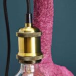 Wall Lamp Ostrich Magenta, shown mounted in a hallway setting
