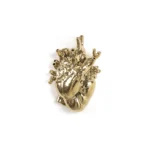 Gold anatomical heart vase styled on a mantel