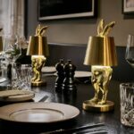 Table Lamp Rabbit LED Glossy Gold, shown illuminated on a bedside table